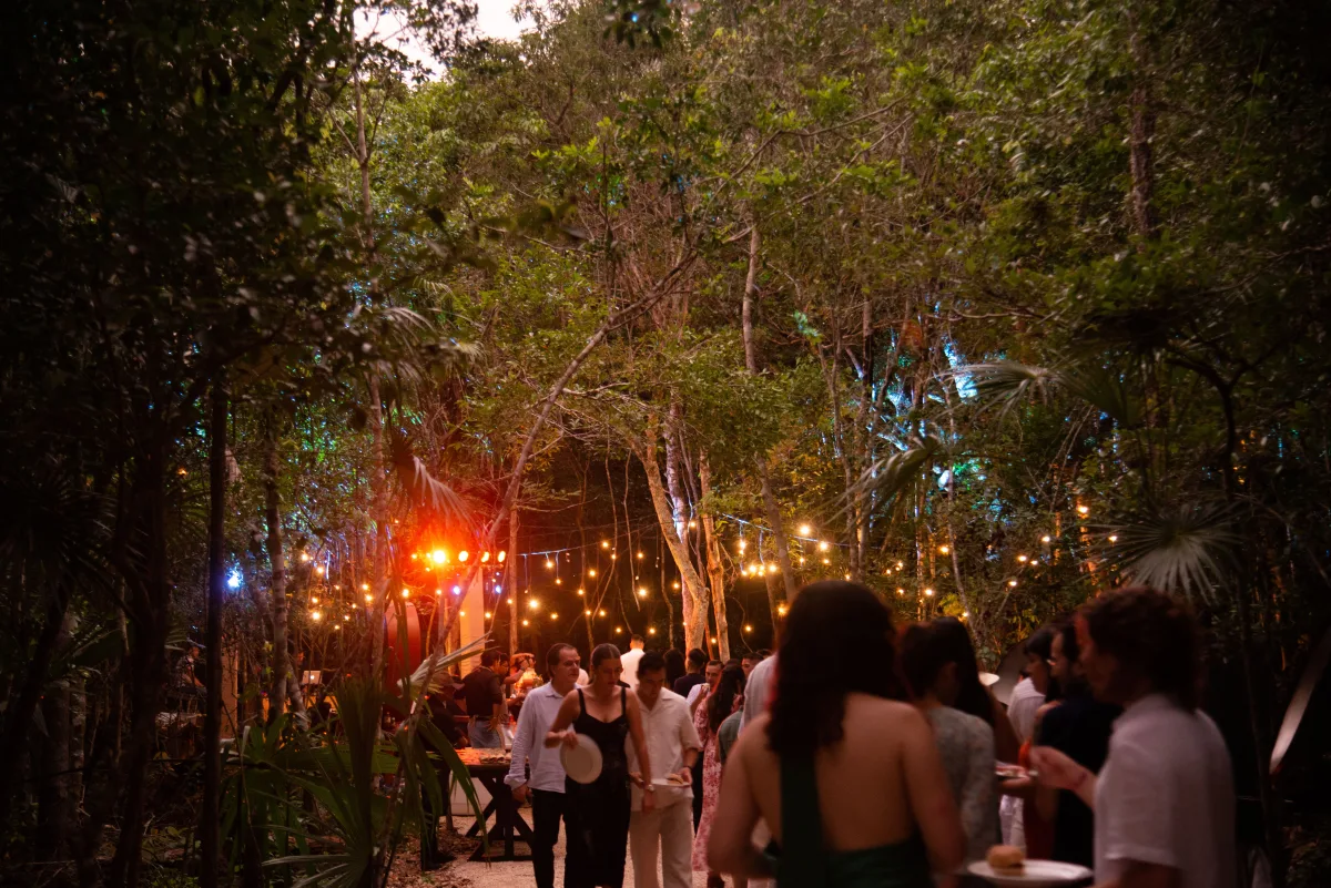 Guests celebrating under string lights deep in the Tulum jungle at Casa Arkaana