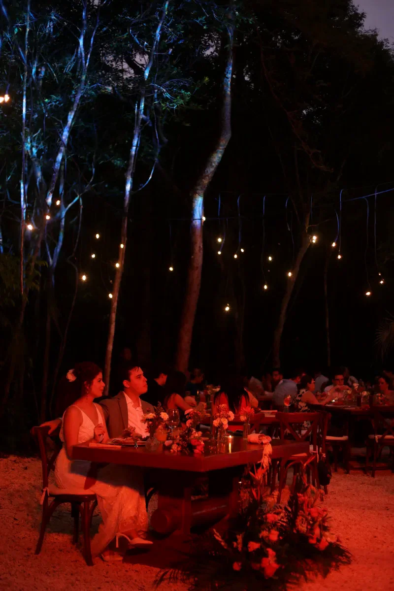 String lights glowing over the jungle wedding dinner at night